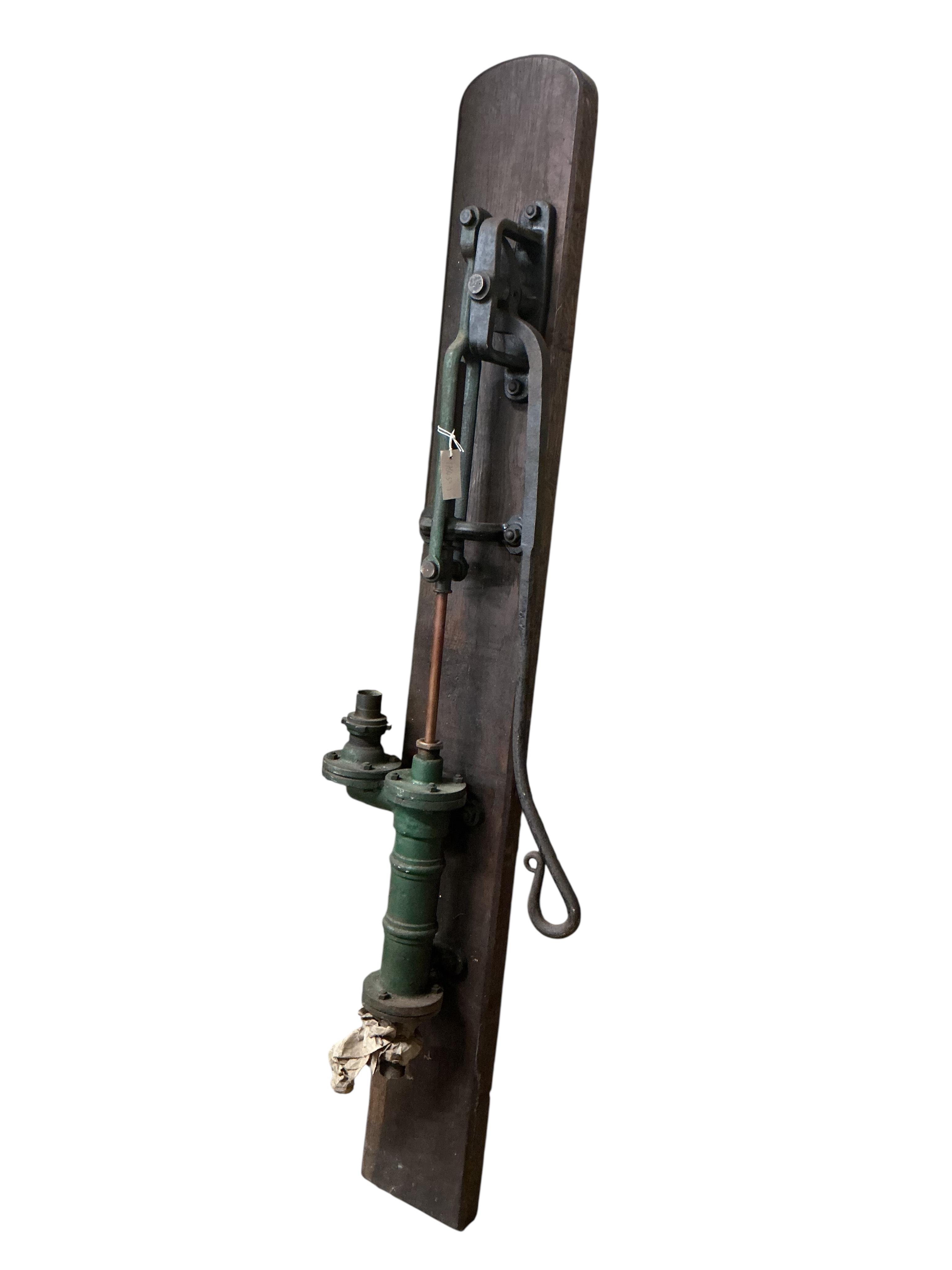 A Victorian cast iron water pump, mounted on a board, height including back board 80cm